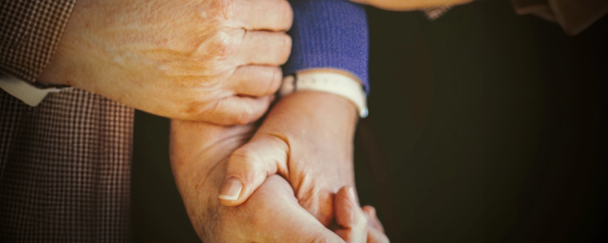 person in blue long sleeve shirt holding babys hand